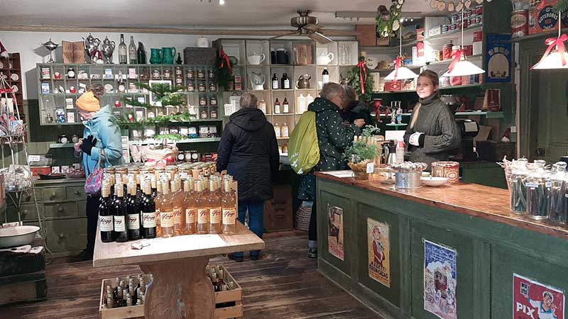 Gäster som julhandlar i lanthandeln på Huseby Bruk under julmarknaden Man shoppar inne i lanthandeln på Husebybruk under julmarknaden.